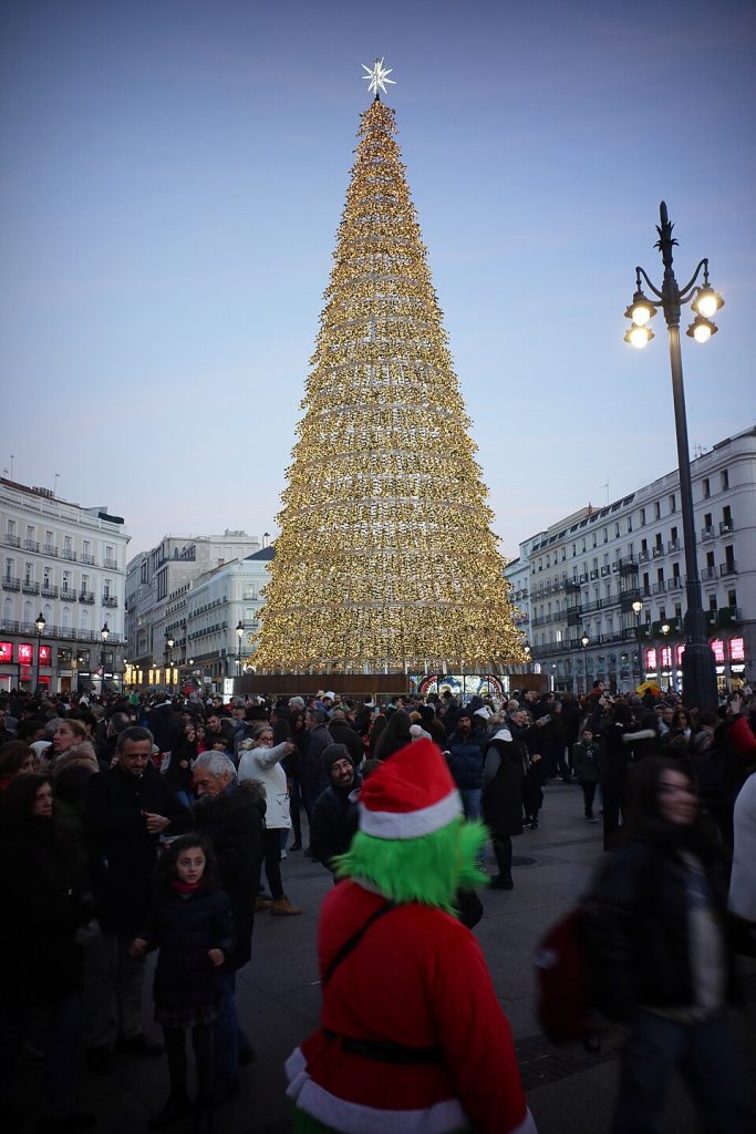 Vista de la Puerta del Sol en Madrid con gente y monumentos alrededor.