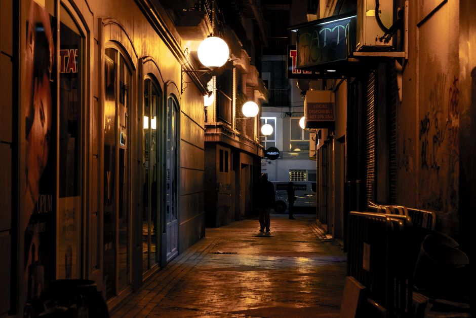 Vida nocturna en Malasaña, Madrid, con luces y personas disfrutando en un ambiente bohemio.