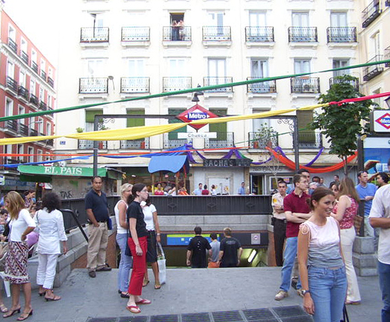 Pareja disfrutando de la Plaza de Chueca en Madrid, un barrio conocido por su diversidad.