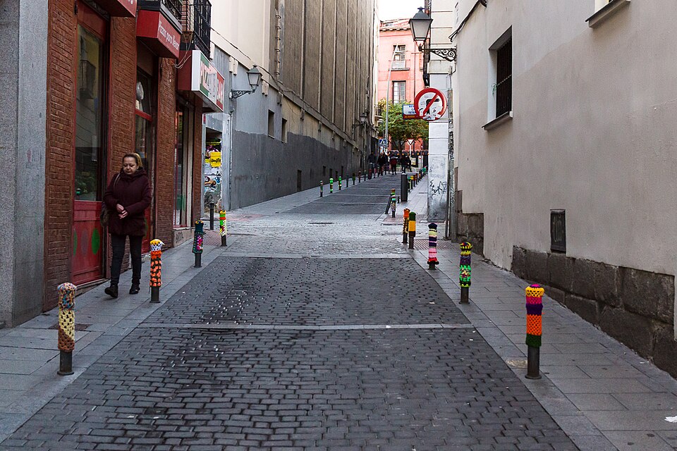 Artista urbano pintando un mural en Lavapiés, destacando la diversidad cultural del barrio.