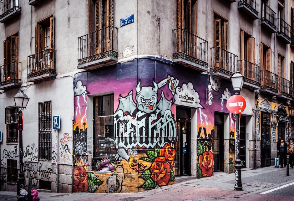 Callejón en Malasaña con arte urbano y grafitis vibrantes.